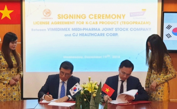 CJ헬스케어 강석희 대표(왼쪽)와 베트남 비메디멕스사 Cuong 대표가 케이캡정 기술수출 계약서에 서명하고 있다.