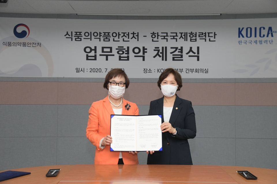식품의약품안전처 이의경 처장(오른쪽)과 한국국제협력단 이미경 이사장이 협약서를 들어보이고 있다. (사진=식품의약품안전처)