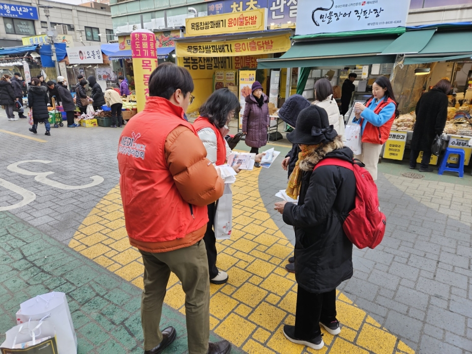 건협 서울서부지부 관계자들이 지역주민을 대상으로 세뱃돈 봉투를 나눠드리는 가두캠페인을 진행하고 있다.