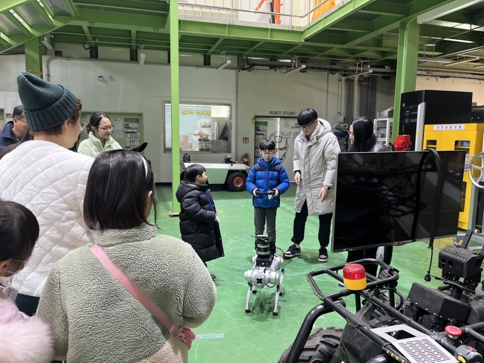 연구원 로봇실증시험시설에서 한 아이가 원자력 방재 로봇을 조종하고 있다.