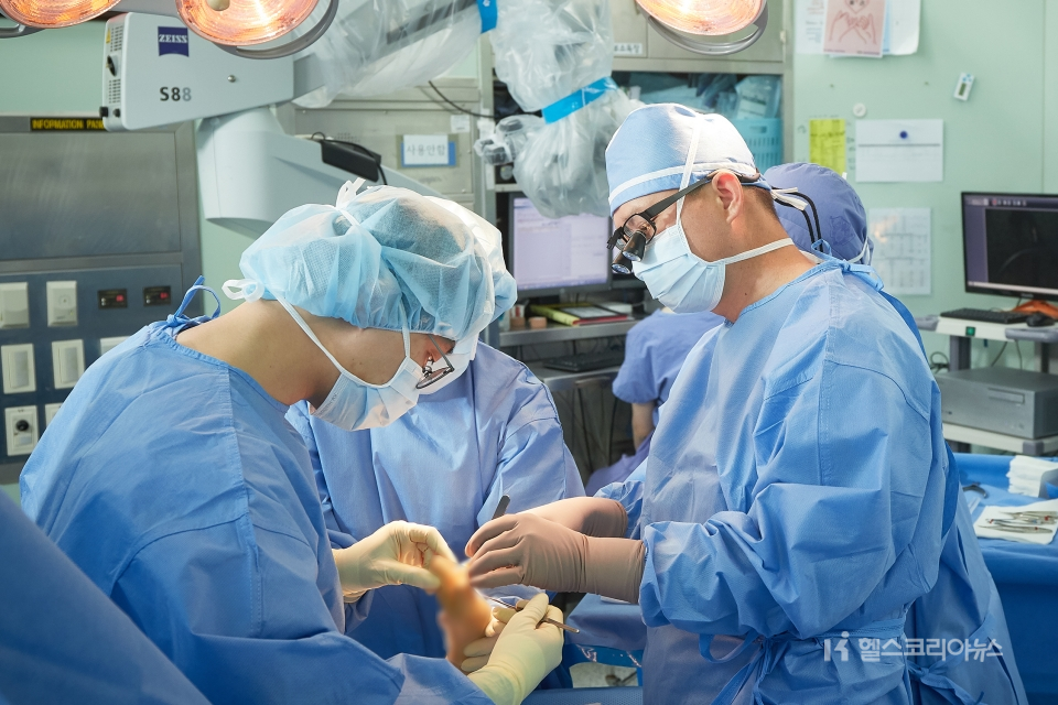 오랜기간 손목터널증후군에 시달려온 한 환자가 대학병원 의료진에게 수술적 치료를 받고 있다.