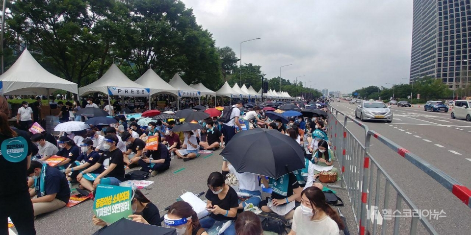 [사진=박정식] 14일 서울 여의도 '전국의사총파업 궐기대회' 참석자들이 우산을 쓰고 행사를 기다리고 있다.