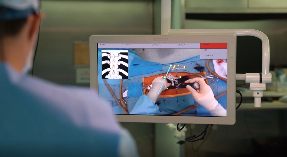 환자 수술 부위에 투영된 AR 기반 오버레이 그래픽으로 나사못이 들어갈 위치를 파악하고 있는 모습.