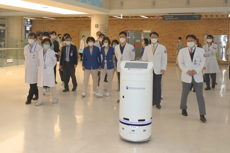 계명대 동산병원 교직원들이 주행중인 약품이송로봇(DS1)을 뒤따르며 관찰하고 있다.