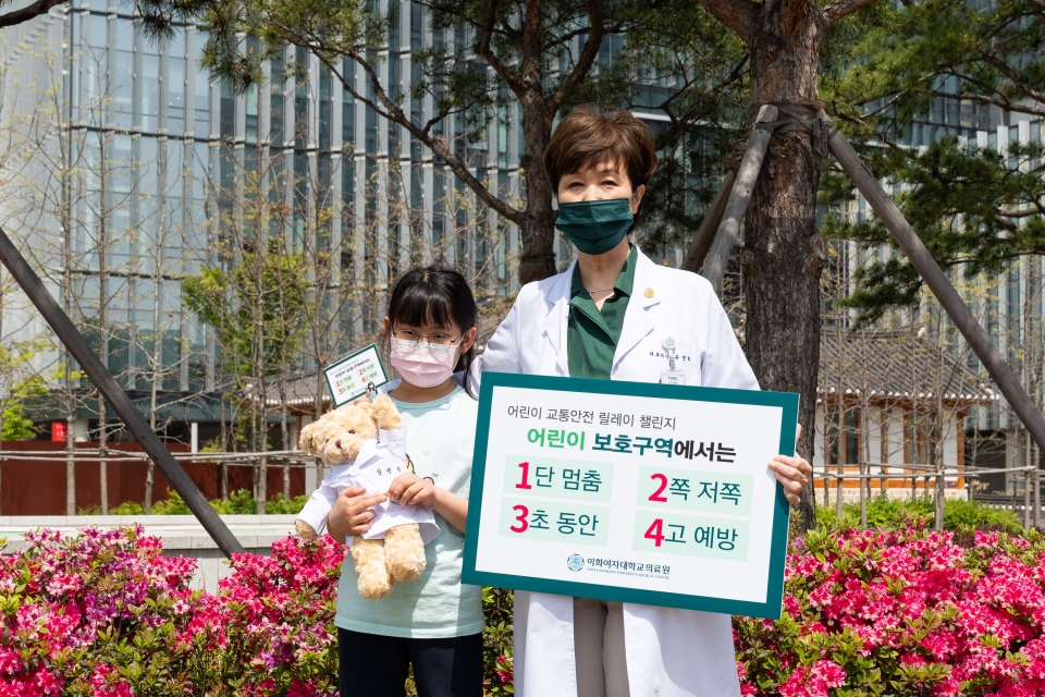 유경하 이화의료원장이 서울 가곡초등학교 3학년 장연규 어린이와 함께 4월 21일 “어린이 보호구역 교통안전 릴레이 캠페인”에 참여하고 있다.