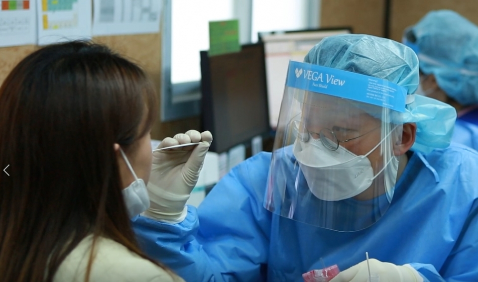 한 여성이 한림대동탄성심병원에 마련된 선별진료소에서 의료진으로부터 코로나19 검사를 받고 있다. [사진=한림대동탄성심병원 제공]